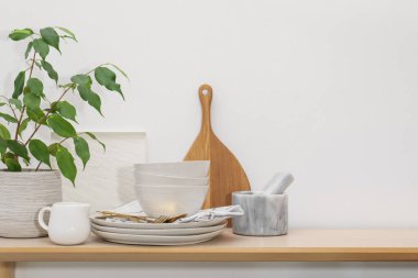 Farklı temiz beyaz bulaşık takımı, çatal bıçak takımı, kesim tahtası ve ağaç dekoru kapalı masa, metin için yer