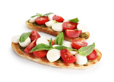 Peynirli, domatesli ve fesleğenli lezzetli sandviçler beyaz üzerine izole edilmiş.