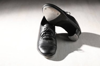 Beyaz tahta zeminde step dansı için bir çift ayakkabı.