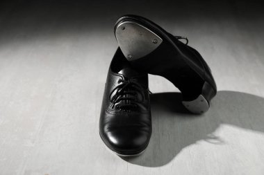 Beyaz tahta zeminde step dansı için bir çift ayakkabı.