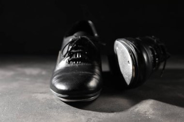 Gri zeminde dans etmek için siyah arka plana karşı bir çift ayakkabı, yakın plan.