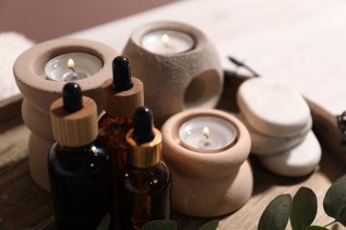 Kozmetik ürünler ve yanan mumlar bulanık arka planda, yakın plan. Spa tedavisi