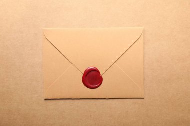 Bej arka planda kırmızı balmumu mühürü olan güzel bir zarf, üst manzara