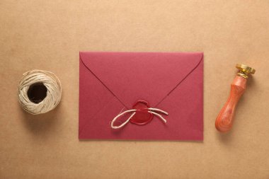 Güzel balmumu mühür, sicim ve zarf bej arka planda, düz yatıyordu.