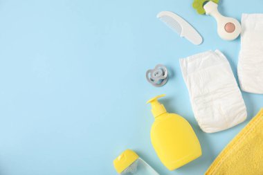 Açık mavi arka planda bebek aksesuarları ve kozmetik ürünleri, düz yatış. Metin için boşluk