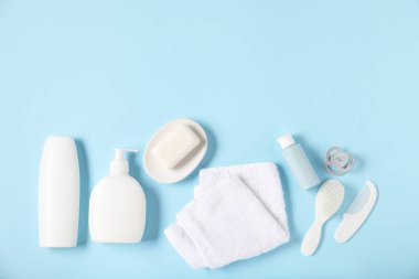 Açık mavi arka planda bebek aksesuarları ve kozmetik ürünleri, düz yatış. Metin için boşluk