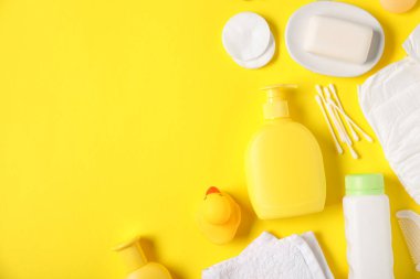 Sarı arka planda bebek aksesuarları ve kozmetik ürünleri. Metin için boşluk