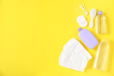Sarı arka planda bebek aksesuarları ve kozmetik ürünleri. Metin için boşluk
