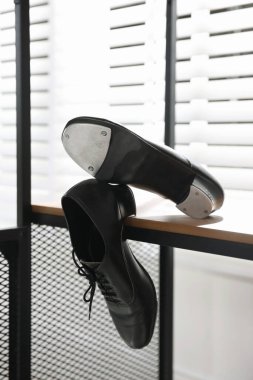 Kapalı alanda ahşap rafta step dansı için bir çift ayakkabı.