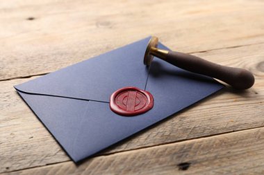 Balmumu mühürlü zarf ve ahşap masaya damgalı, yakın plan.