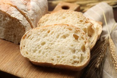 Taze ekmek ve buğday başakları masada, yakın plan.