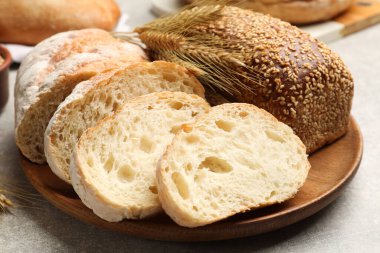 Gri masada farklı ekmek ve buğday çivileri, yakın plan.