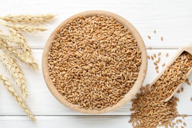 Kasede buğday taneleri, beyaz ahşap masada kepçeler ve çiviler, düz uzanmış