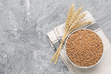 Kasede buğday taneleri ve gri masada sivri uçlu çiviler. Metin için boşluk