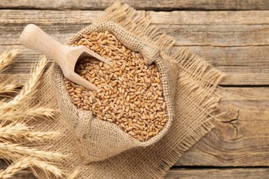 Çuval bezinde buğday taneleri, tahta masada kepçe ve çiviler, düz yatak. Metin için boşluk