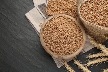 Kasede buğday taneleri, çuval bezi torbası ve siyah masada çiviler. Metin için boşluk