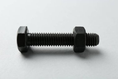 Metal cıvata ve fındık beyaz arka planda, yakın plan. Donanım aracı