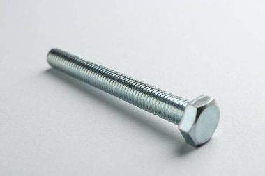 Beyaz arka planda metal bir cıvata, yakın plan. Donanım aracı