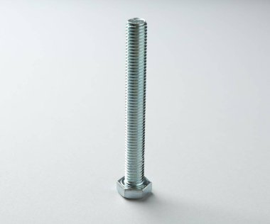 Beyaz arka planda bir metal cıvata. Donanım aracı