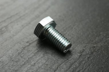 Bir metal cıvata siyah masada, yakın plan.