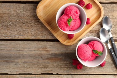 Kâselerde naneli ahududu şerbeti, kaşıklar ve ahşap masada taze böğürtlenler. Metin için boşluk