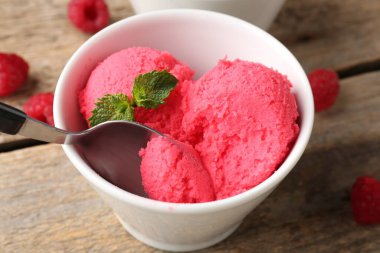 Lezzetli ahududu şerbeti, ahşap masada kaşıkla nane şekeri, yakın plan.