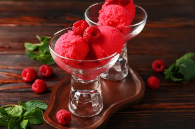 Tatlı kaselerinde nefis ahududu şerbeti, ahşap masada nane ve taze böğürtlen, yakın plan.