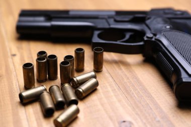 Mermiler ve silah ahşap masada, yakın plan.