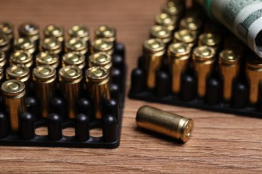 Kurşunlar ve dolarlar ahşap masada, yakın plan.