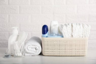 Tuğla duvarın yanındaki masada bir sürü bebek aksesuarı var.