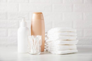 Tuğla duvarın yanındaki masada bir sürü bebek aksesuarı var.