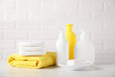 Tuğla duvarın yanındaki masada bir sürü bebek aksesuarı var.