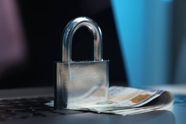 Siber güvenlik. Metal asma kilit ve dolar dizüstü bilgisayarda, yakın plan.