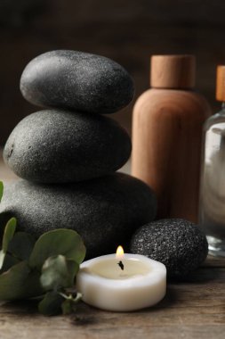 Kozmetik ürünleri ve spa taşlarıyla ahşap masaya yakın plan kompozisyon.
