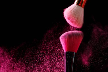 Siyah arka planda pembe göz farlı makyaj fırçaları, yakın plan. Metin için boşluk