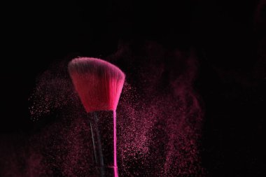 Siyah arka planda pembe göz farlı makyaj fırçası, yakın plan.