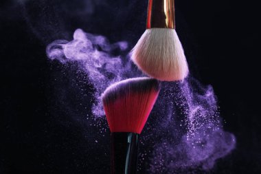 Siyah arka planda mor göz farlı makyaj fırçaları, yakın plan