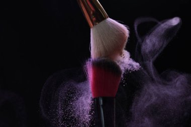 Siyah arka planda mor göz farlı makyaj fırçaları, yakın plan