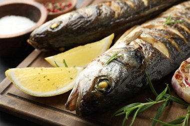 Gri masada biberiye ve limonla servis edilen lezzetli kavrulmuş deniz kabuğu balığı, yakın plan. Ev yapımı deniz ürünleri yemeği.