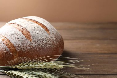 Tahta masada taze ekmek ve yeşil buğday çivileri, yakın plan. Metin için boşluk