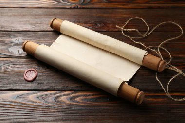 Eski kaydırma, balmumu mühür ve sicim ahşap masada, yakın plan.