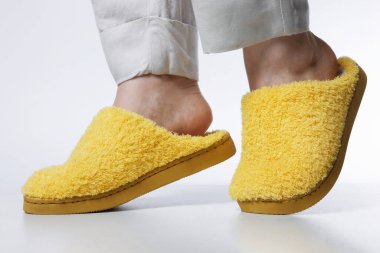 Hafif sarı terlikli kadın beyaz arka planda, yakın plan.