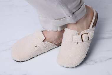 Beyaz mermer zeminde, yumuşak terlikli kadın, yakın plan.