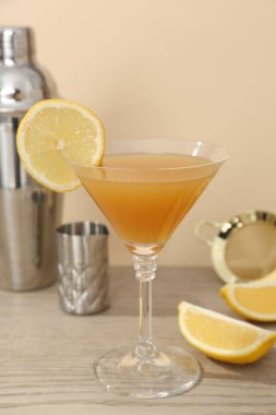 Bardakta lezzetli limon kokteyli ve ahşap masada barmen ekipmanı, yakın plan.