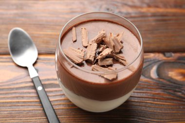 Lezzetli çikolata panna cotta cam ve kaşık ahşap masa, yakın çekim
