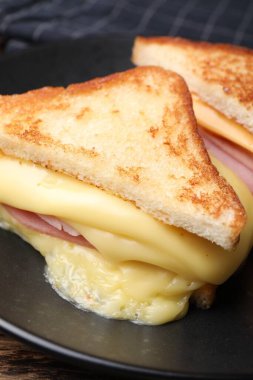 Eritilmiş peynirli ve jambonlu lezzetli sandviçler, yakın plan.