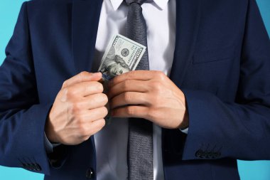 Adam mavi arka plana dolar koyuyor, yakın plan.