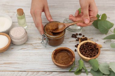 Beyaz ahşap masada doğal vücut ovuşturan kadın, yakın plan.