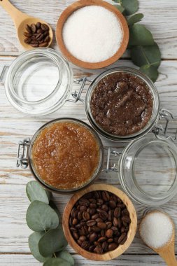 Cam kavanozlarda doğal vücut önlükleri ve ahşap masa üzerindeki malzemeler.