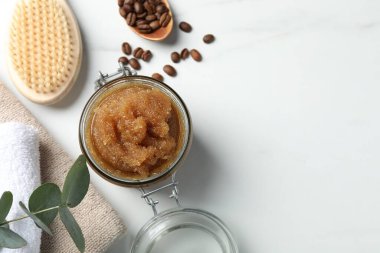 Doğal vücut fırçası, kahve çekirdekleri ve okaliptüs yaprakları beyaz masada, düz yerde. Metin için boşluk